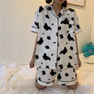 Femboy in black and white cow print short sleeve top and shorts pajama set