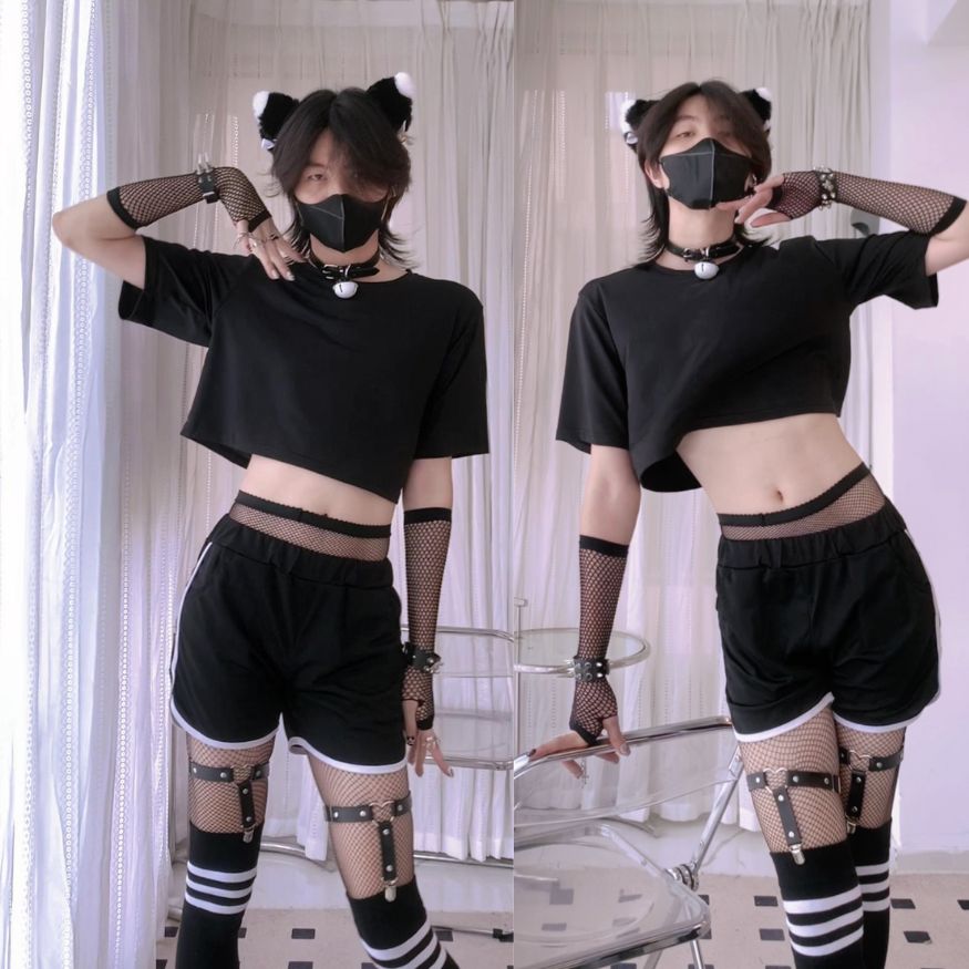 Person wearing a black outfit with cat ears and fishnet stockings in a room.