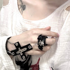 Hand wearing black gothic cross skull ring chain bracelet