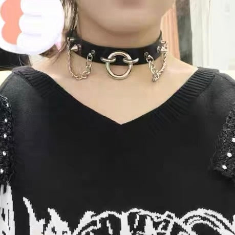 Black choker necklace with chain details worn by a person