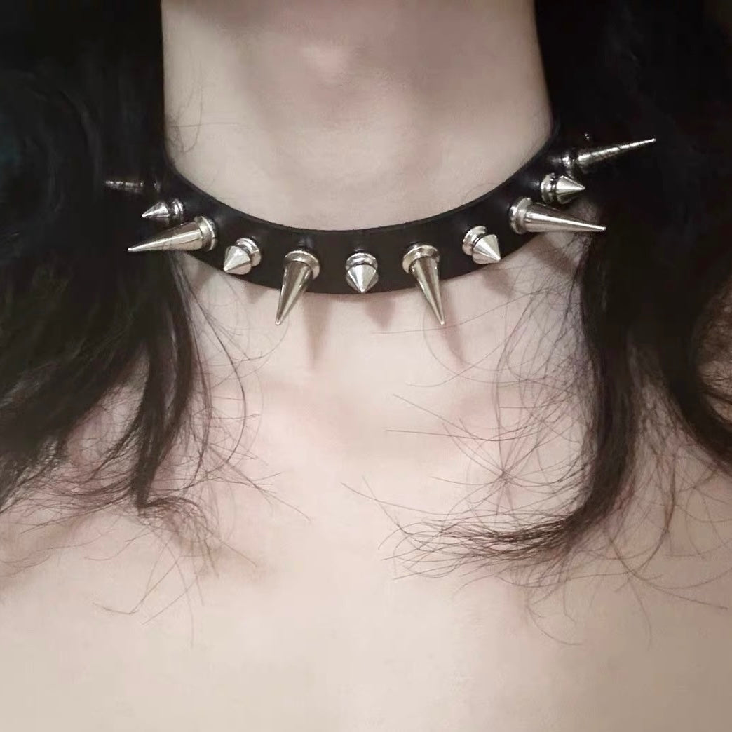 Black leather choker with silver spikes worn by a person