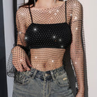 Person wearing a sheer fishnet top with a star design and beige pants on a white background