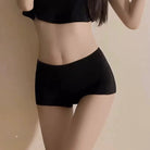 Person wearing black underwear on a beige background