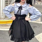 Person wearing a black and blue outfit with a black skirt and blue blouse.