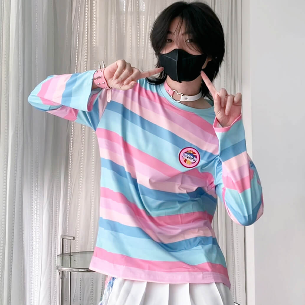 Person wearing a colorful striped sweater and white skirt indoors.