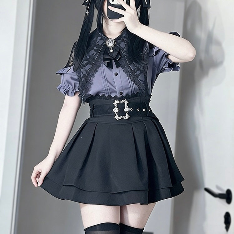 A person wearing a black and purple gothic Lolita-style outfit, featuring a sheer gray lace top, a black pleated skirt, and a decorative silver buckle belt, taking a mirror selfie.
