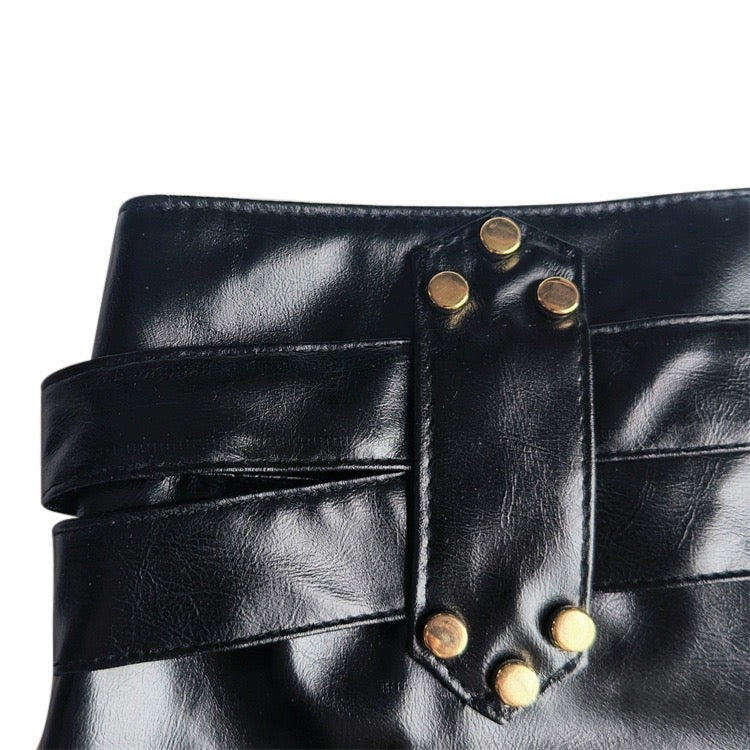 Black leather shorts worn by a person on a plain background