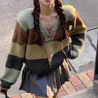 A femboy wearing a v neck lace up color block sweater