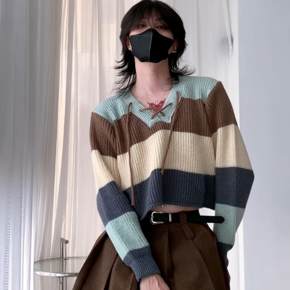 A femboy wearing a v neck lace up color block sweater