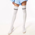 White thigh-high socks with black stripes worn by a person on a white background