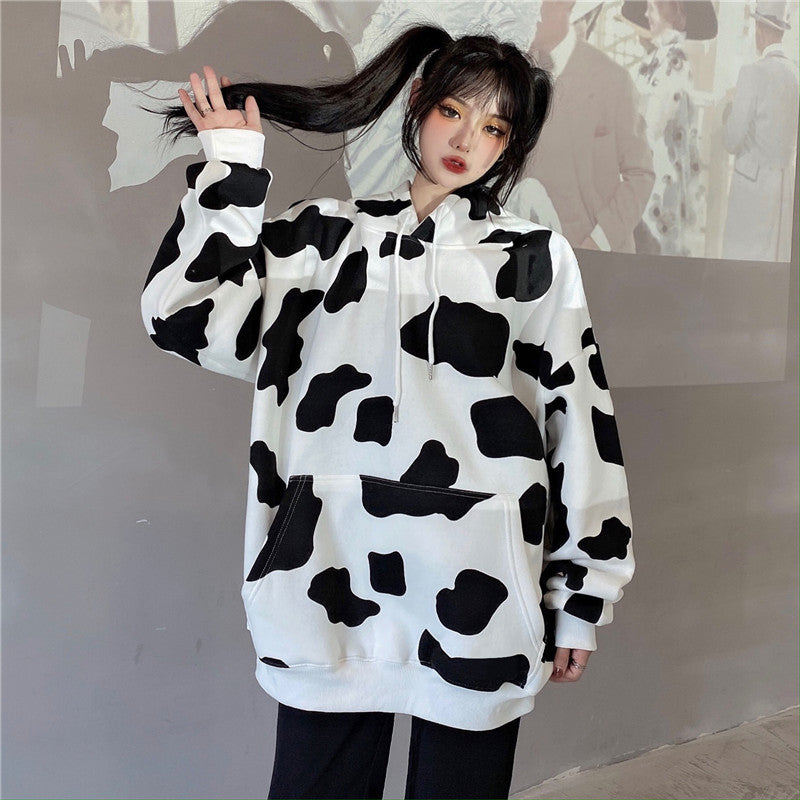 Femboy wear a black and white cow print oversize hoodie