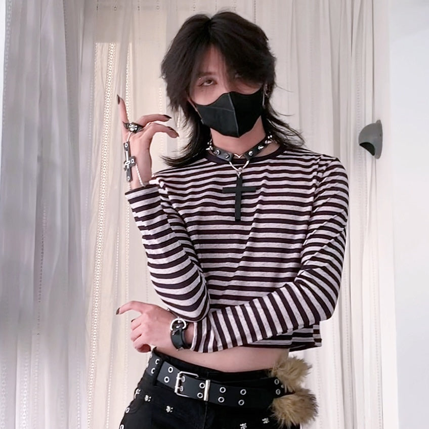 Femboy wearing a black and white striped shirt with a black face mask indoors.
