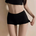 Person wearing black shorts on a beige background