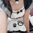 Person wearing a white apron with black paw prints and a bow tie design.
