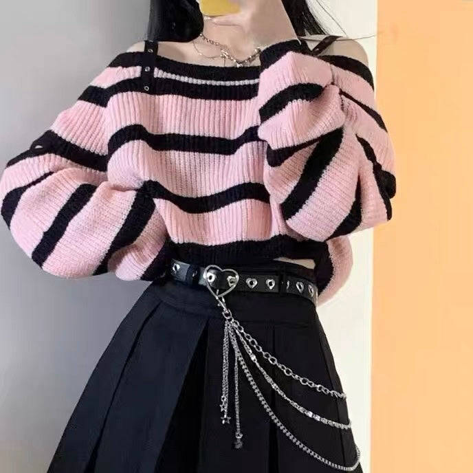 Person wearing a pink and black striped sweater with a black skirt and chain belt.