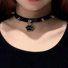 Femboy in punk leather choker with cat paw