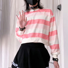 Femboy wearing a pink and white striped sweater with a black skirt, standing against a neutral background.