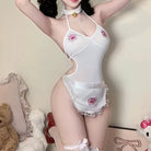 Person wearing a white lingerie set with pink paw prints in a room with stuffed animals.