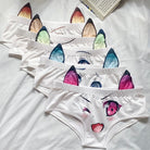 Set of white underwear with colorful cat ear and eye designs on a white background.