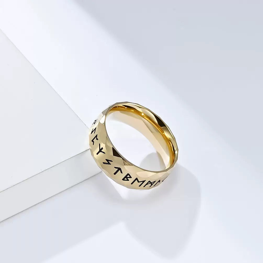 Gold ring with engraved text on a white background