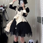 Person wearing a black and white dress with lace details, taking a mirror selfie.