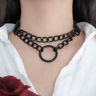 Person wearing a black chain necklace with a white shirt