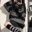 Femboy wear a gray and black oversize sweater