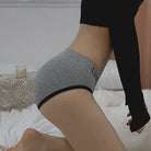 Person wearing a gray compression sleeve on their wrist with a blurred background