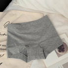 Gray cotton boyshorts on a surface with text and a bowl of fruit in the background