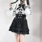 Person wearing a black and white outfit with a black skirt and white top.