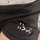Black pants with a white logo on the knee area.