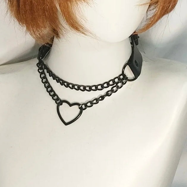 Black chain choker necklace with heart design on a mannequin neck.