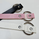 Three leather o ring choker on a light gray background