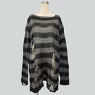 A black and gray soversized striped distressed ripped sweater on a mannequin torso against a solid gray background.