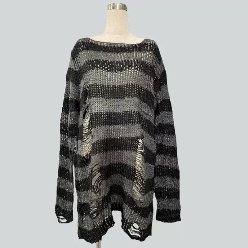 A black and gray soversized striped distressed ripped sweater on a mannequin torso against a solid gray background.