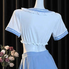 White blouse with blue trim on a mannequin against a black curtain background
