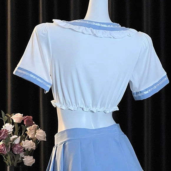 White blouse with blue trim on a mannequin against a black curtain background