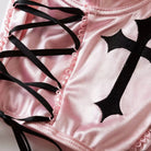 Close-up of pink shorts with black cross design and lace-up details.
