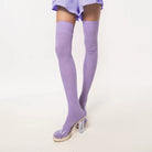 Purple thigh-high socks with clear high-heeled shoes on a white background