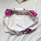 White headband with pink and black accents on a light gray background