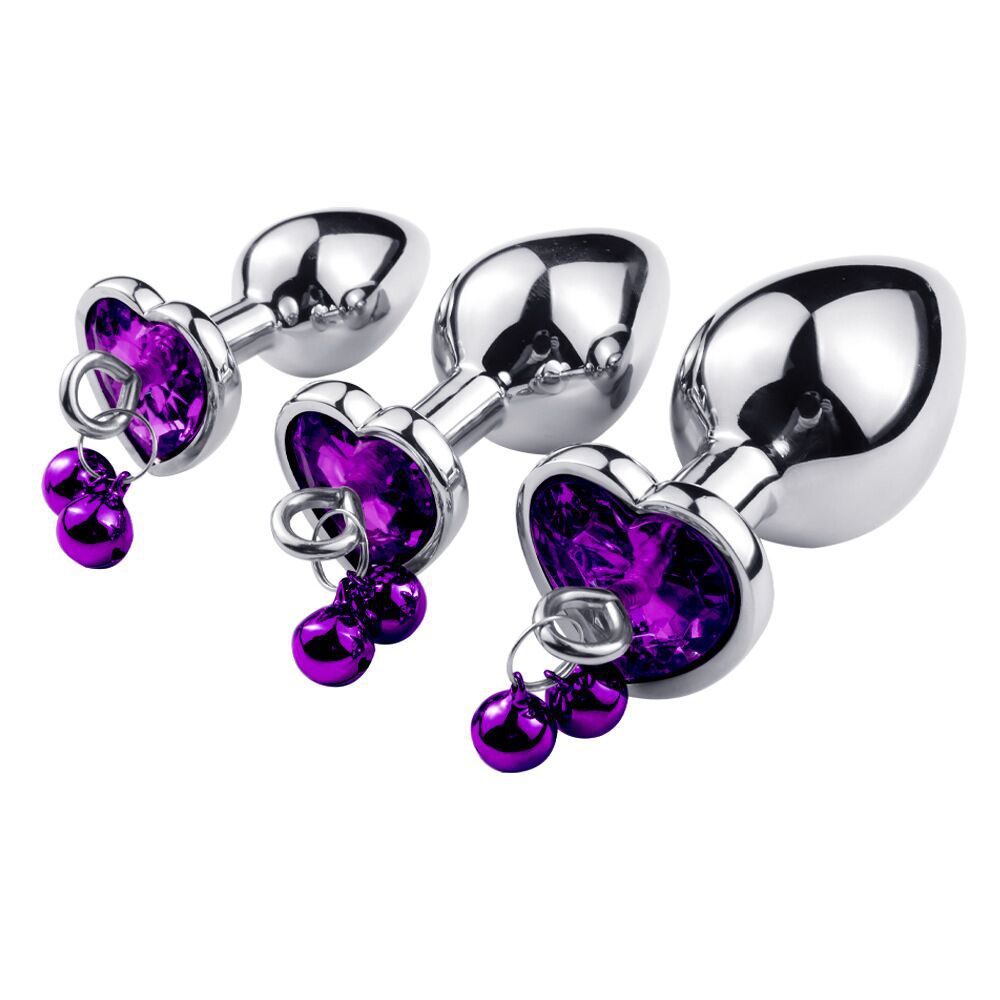 Metallic anal plugs with purple heart-shaped crystals on a white background