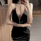 Person wearing a sexy black backless lingerie dress standing indoors.