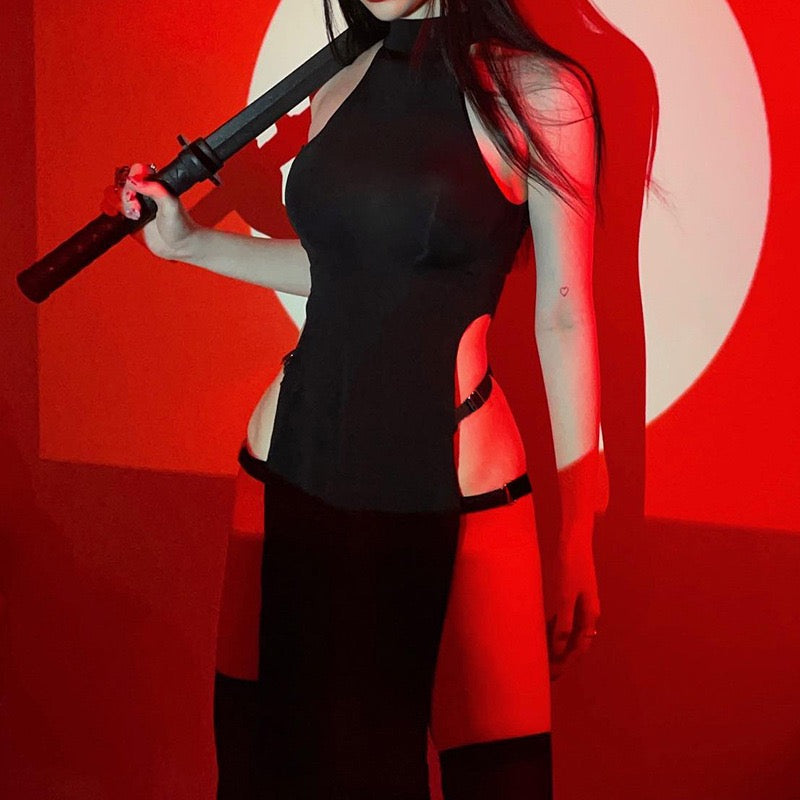 Person in a black outfit holding a weapon against a red background
