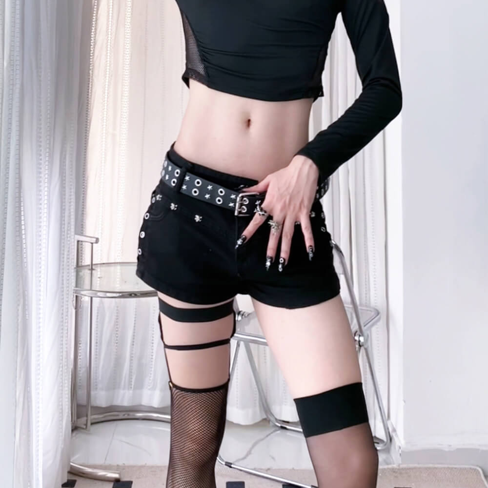 Black shorts with a studded belt worn by a person, with a neutral background