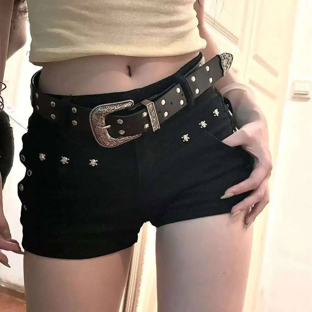 Black shorts with a studded belt worn by a person, with a neutral background