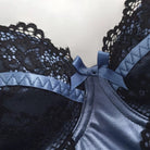 Black lace camisole with a blue ribbon on a light gray background