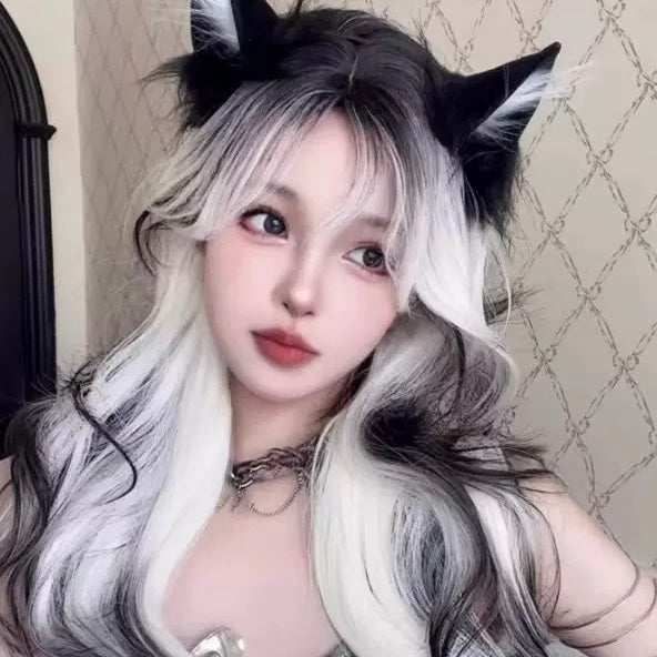 Person with cat ears and long hair in a room with patterned wallpaper