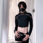Person wearing a black outfit with sheer panels and a mask indoors.