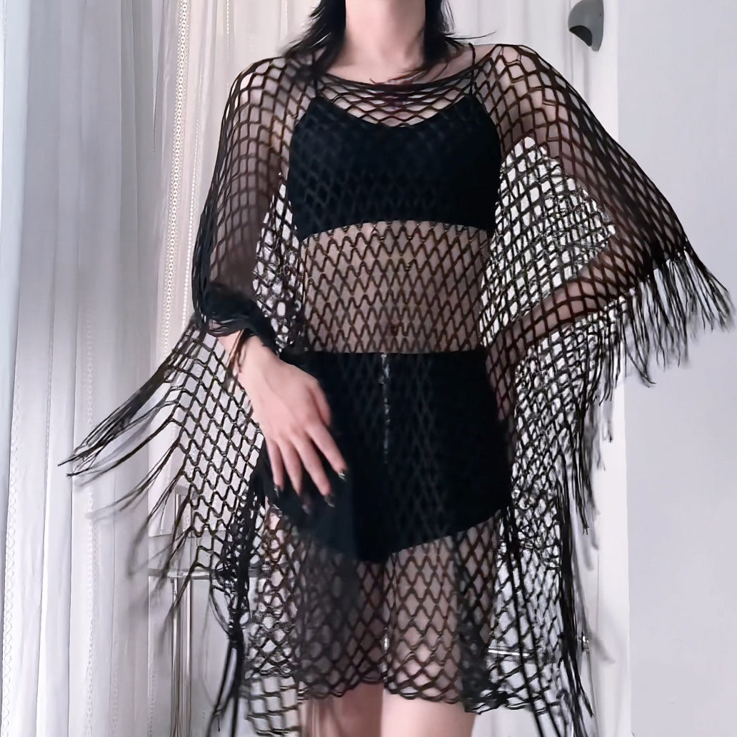 Person wearing a sheer mesh top and cargo pants against a plain background