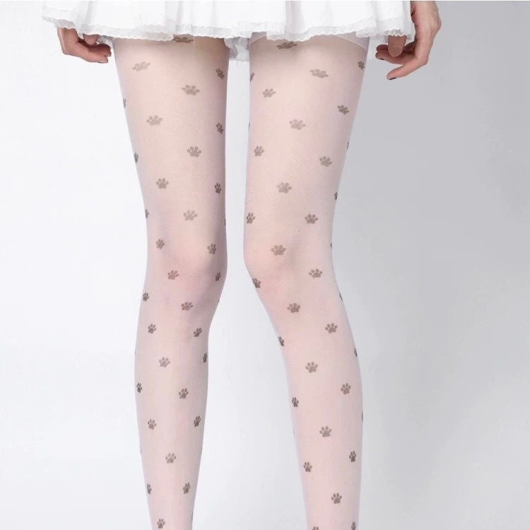 Sheer tights with paw print pattern worn by a person on a white background